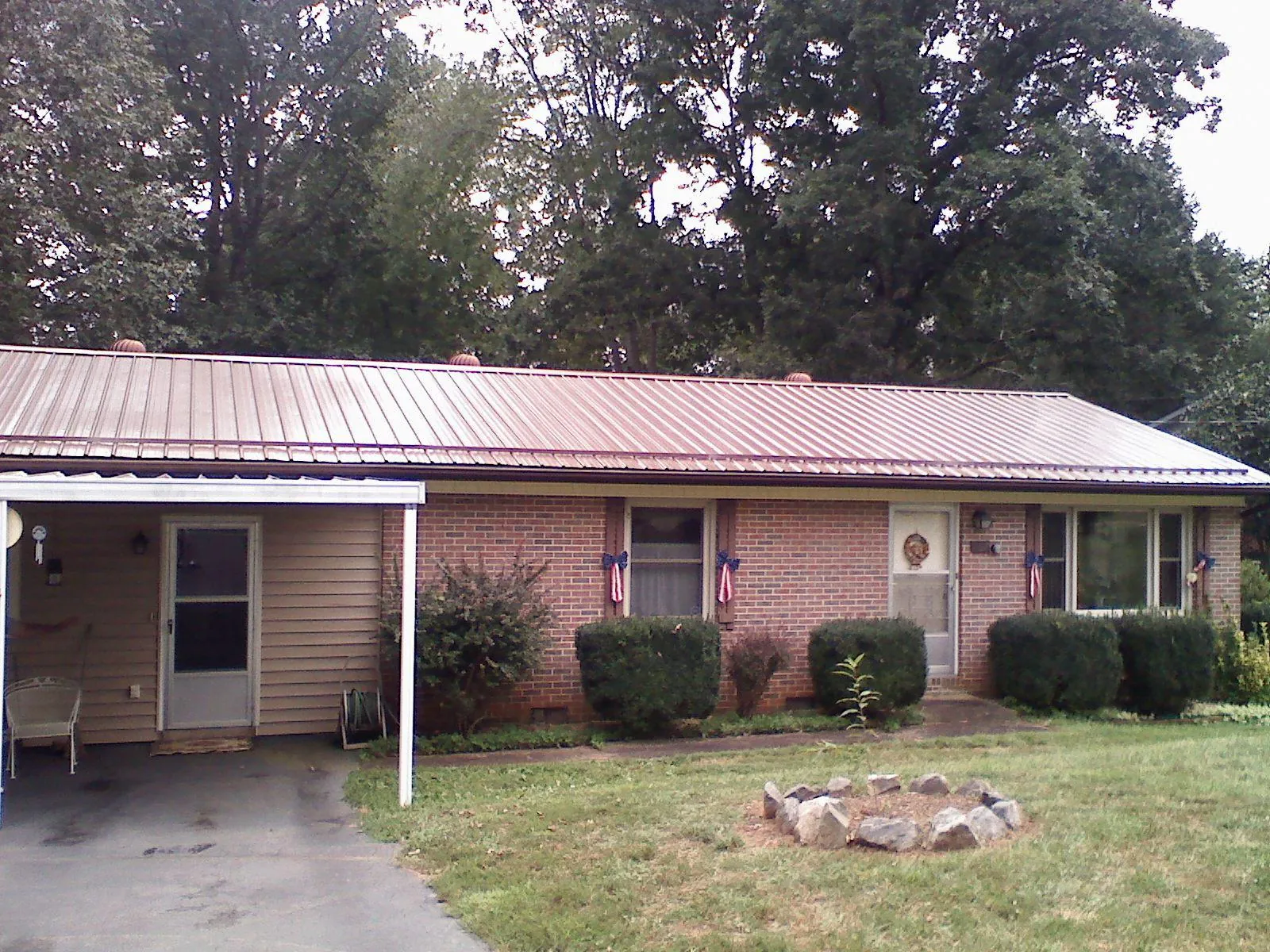 Bronze metal roof and carport on a brick ranch home — Roof Repair work by our crew in Sharon Center